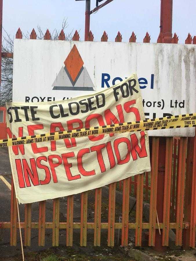 A banner reading "Site closed for weapons inspection" stands in front of the entrance sign of an arms company called Roxel.