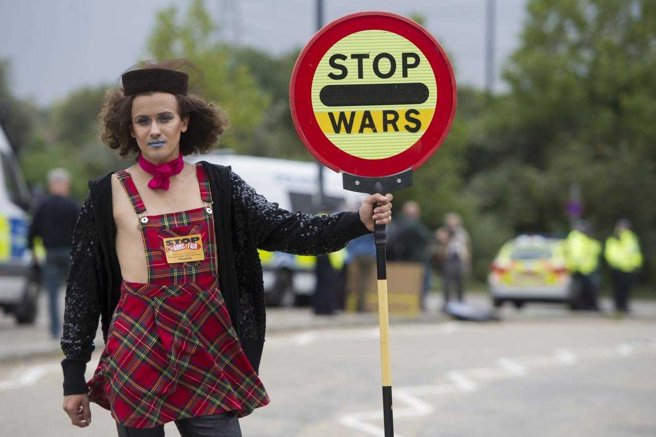 Someone blocks a road outside the DSEI arms fair with a traffic sign reading "stop wars"
