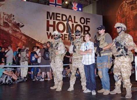 A boy posing with mock soldiers at Gamescom video games festival in Cologne, August 2012.