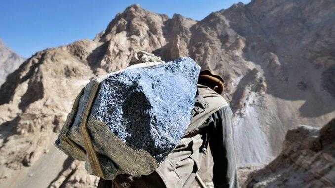 A man carries a large piece of lapis, a semi-precious stone, in Afghanistan.
