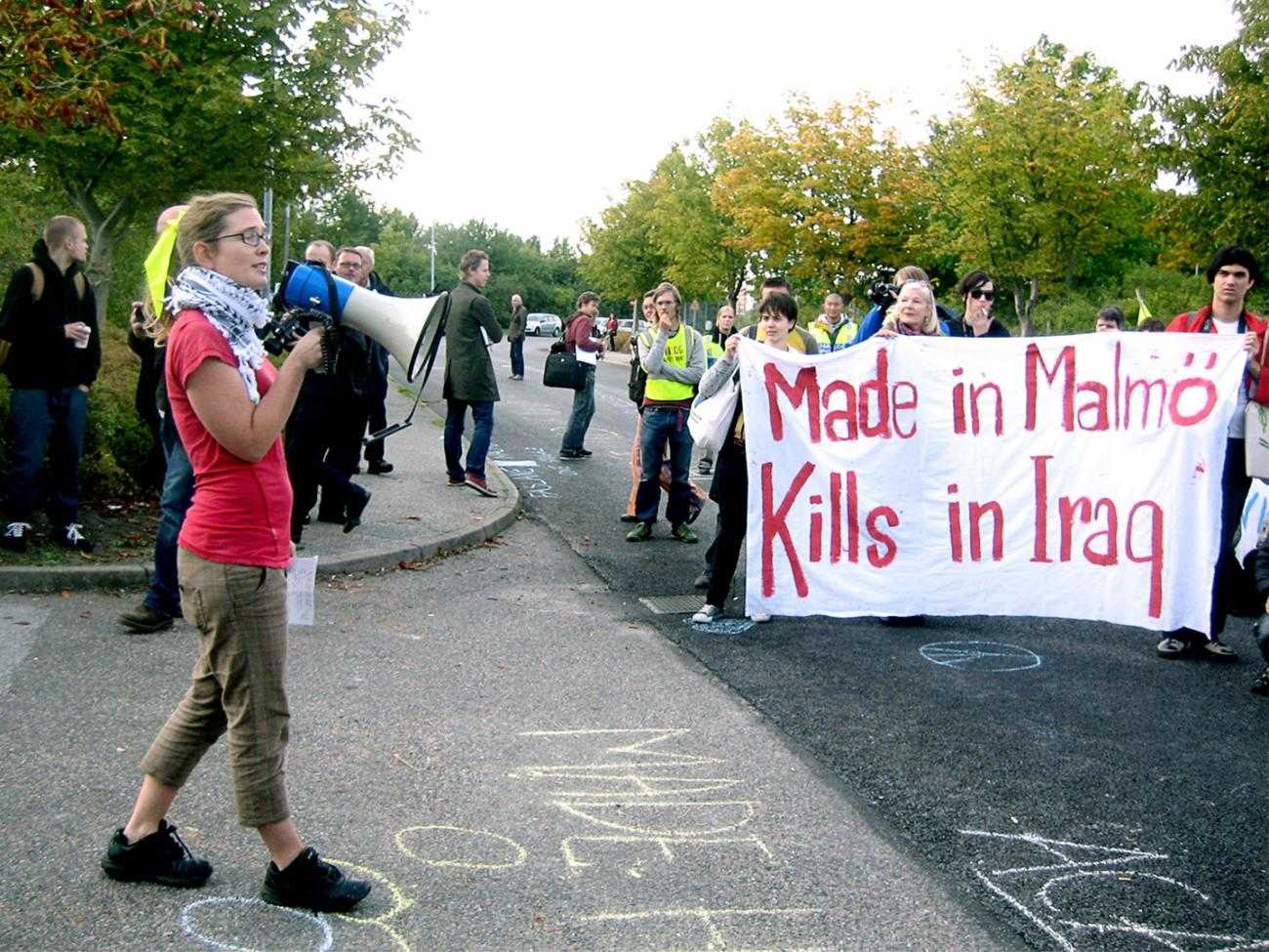 A protest out side Aimpoint's factory. A banner reads "Made in Malmo, Kills in Iraq"