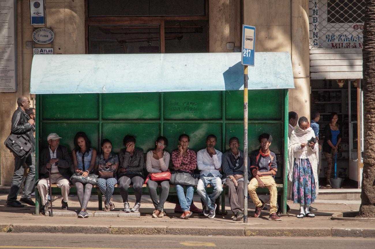 People sitting waiting at a bus stop