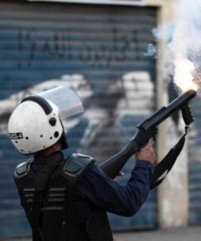 A Bahraini police officer fires tear gas