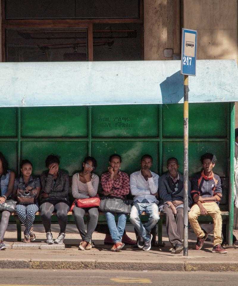 Les gens assis en attente à un arrêt de bus