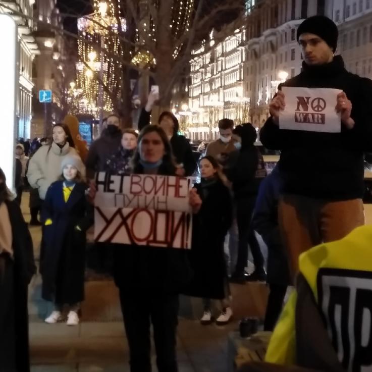 Varias personas participan en una protesta en Rusia. Llevan carteles que dicen "no a la guerra"